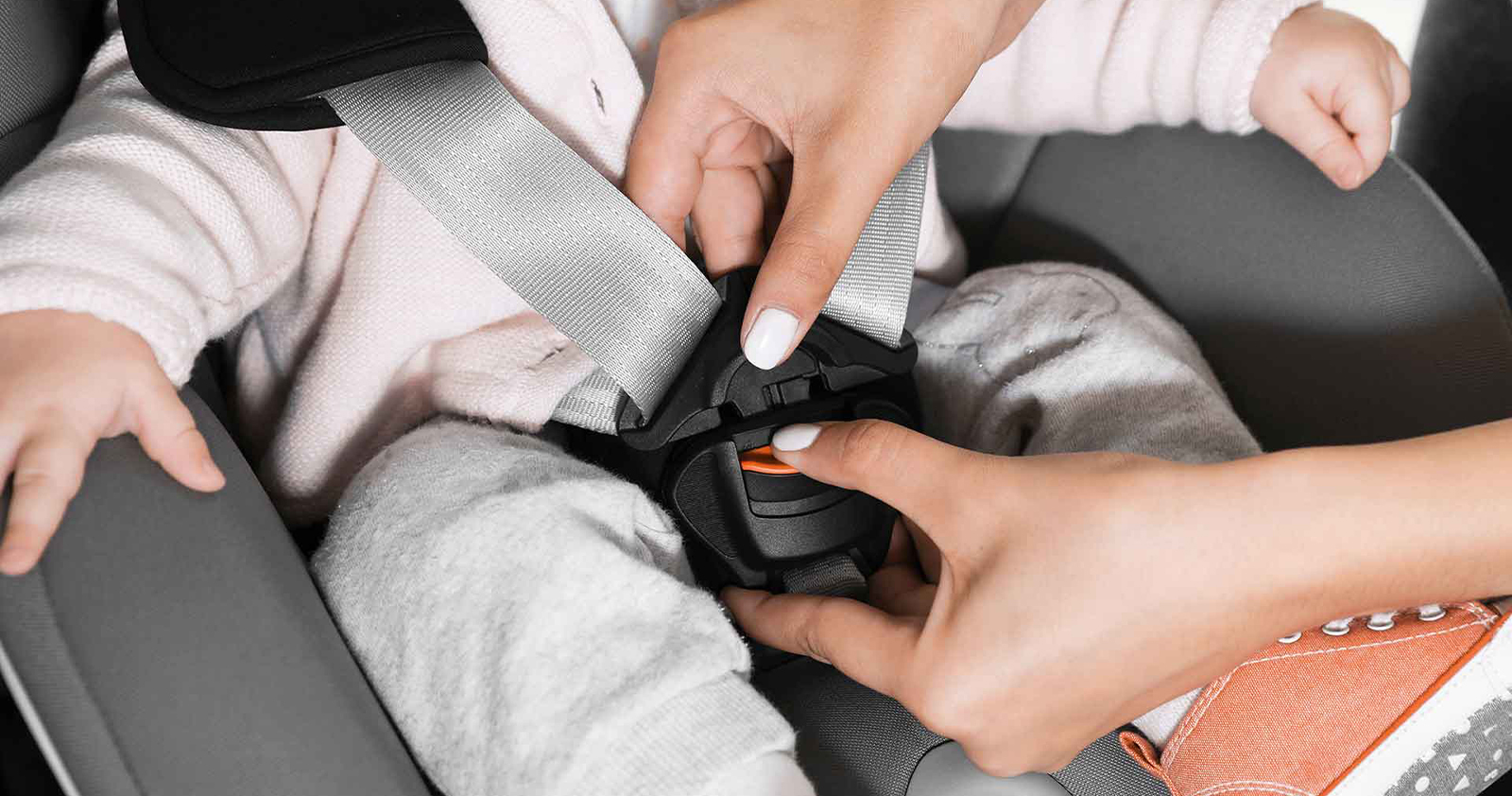Woman's hand securely car seat for child