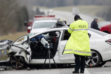 Police officer taking photos of car accident on highway