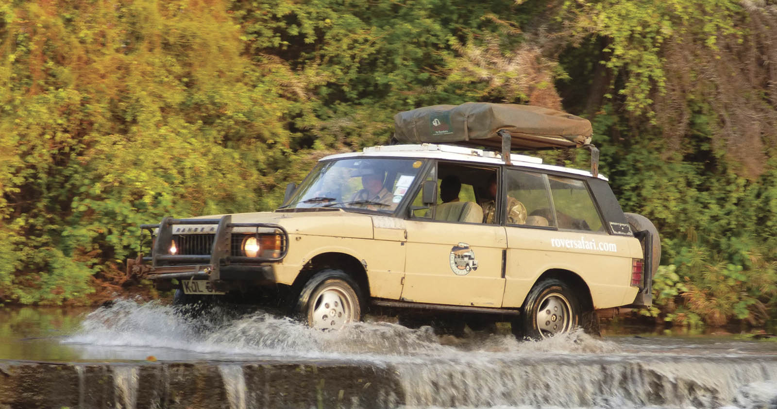 First-gen beige Range Rover crossing river in Kenya