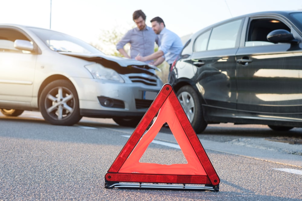 Warning reflective triangle in car crash scene